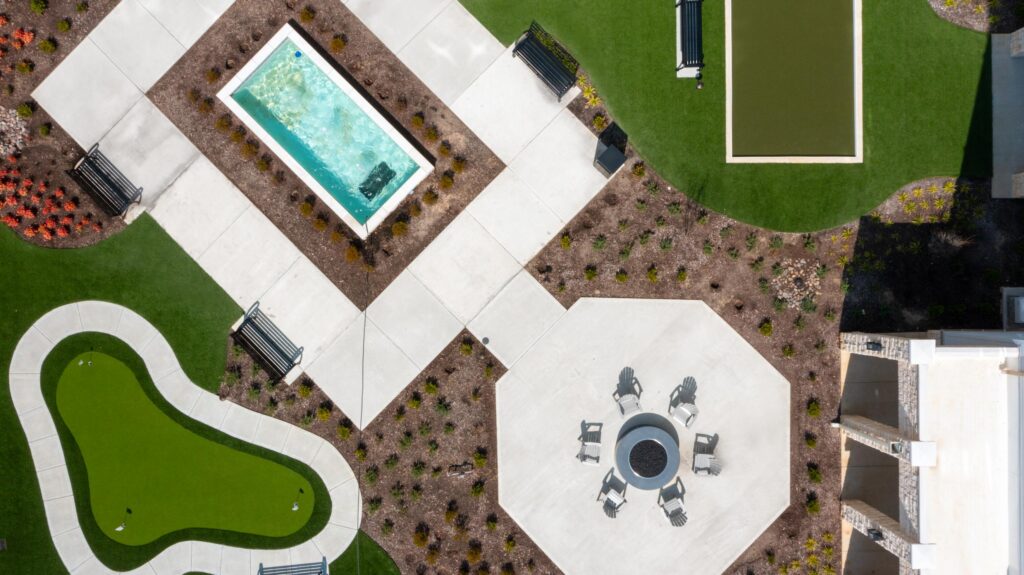 Aerial view of the courtyard with campfire pit, water fountain, bocce pit, and putting green.