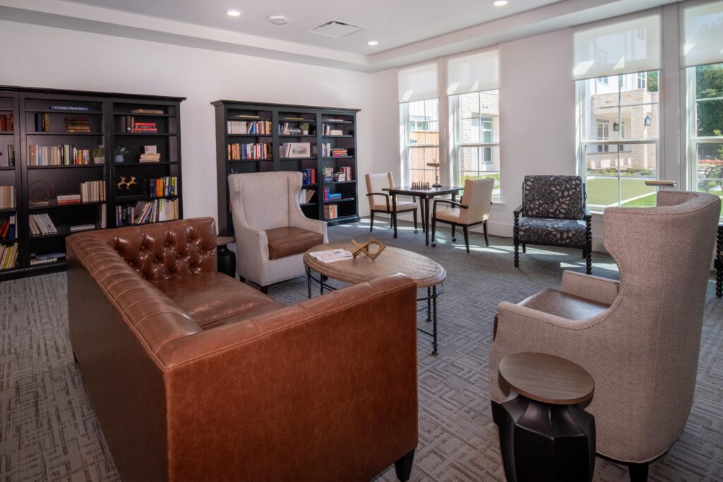 Interior image of a social area with comfortable seating, chess table, and bookcases.